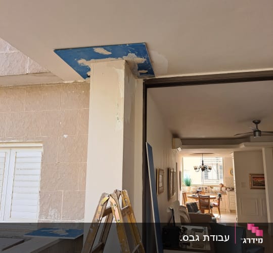 עבודת חיפוי עמוד בלוחות גבס כחולים עמידים בלחות במהלך שיפוץ
